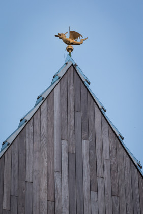 Op de voorgrond de nieuwe stadshal van Gent, er bovenop de Draak van Gent die op het Belfort staat.