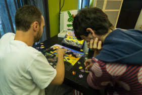 Minor Ndako, Opvang en begeleiding voor minderjarigen en hun context, vluchtelingen, een begeleider puzzelt samen met een jongere.