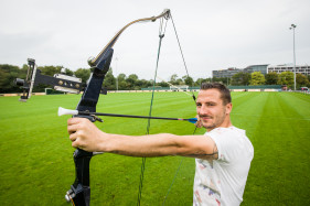 Danijel Milicevic, profvoetballer bij KAA Gent doet zijn overwinningssymbool met een echte pijl en boog.